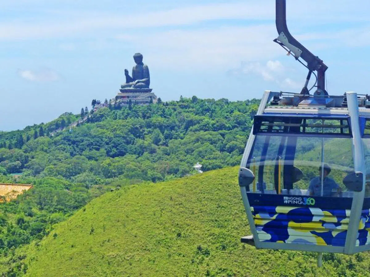 在香港大屿山，游客乘坐昂坪360缆车在云雾中穿梭，观赏迷人的山海景，以及天坛大佛。（曾兄弟）
