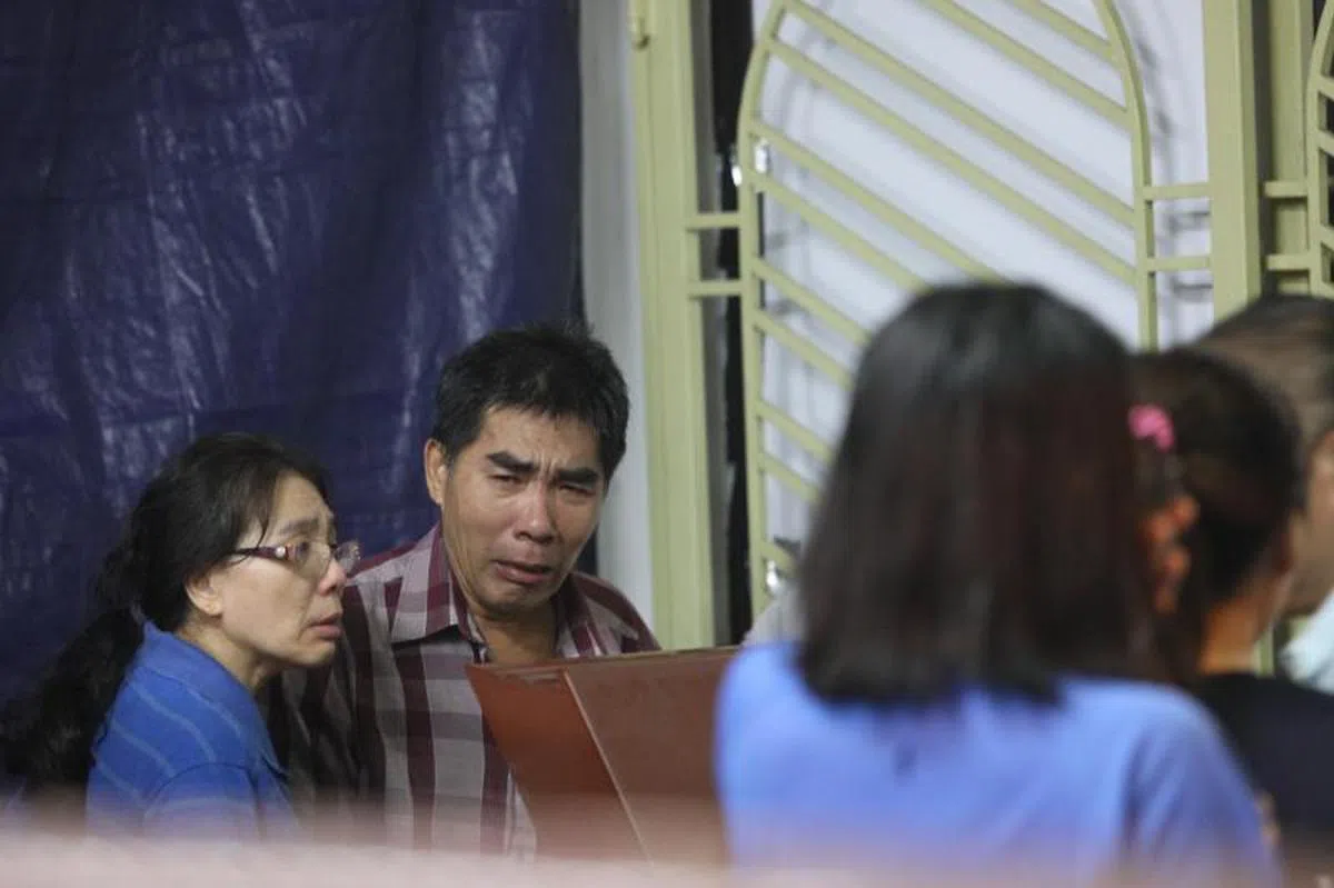  郭俨进遗体昨晚被运回马来西亚马六甲，父亲（右）与姑姑看到棺木泣不成声。（联合晚报） 