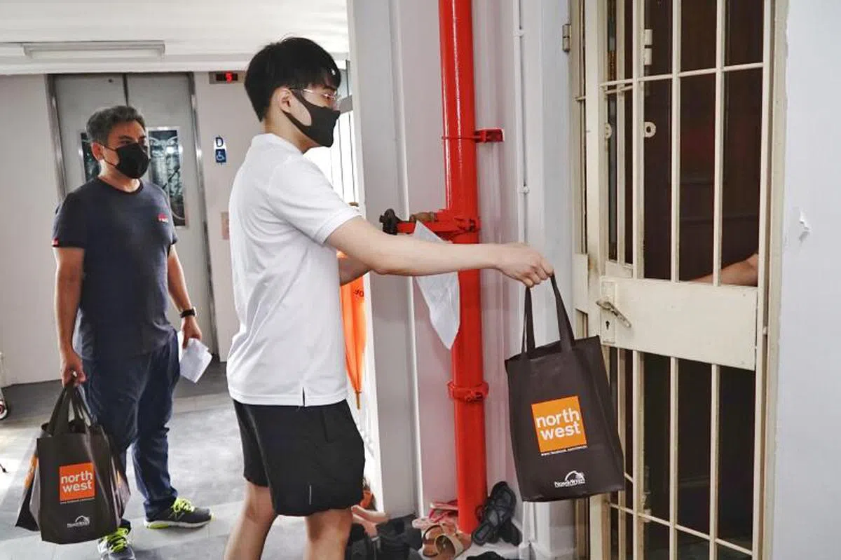 义工给居家康复的冠病确诊者送居家关怀包。（每日新闻）