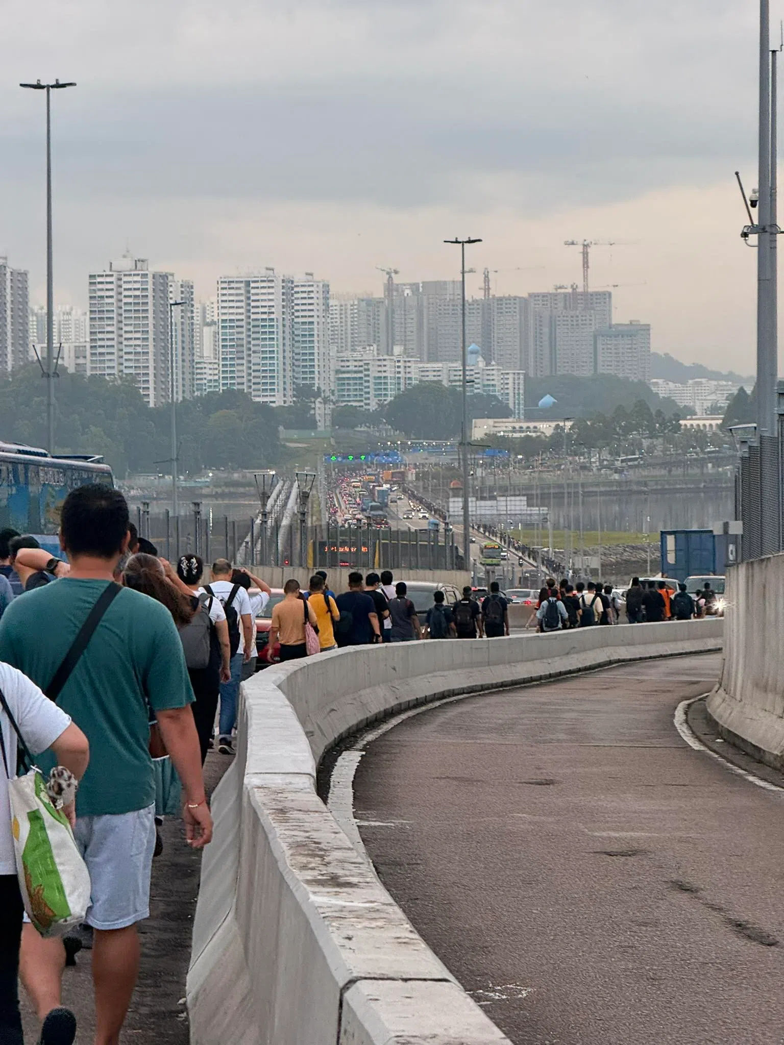 由于跨境巴士久候不至，一些越堤族为避免上班迟到，选择步行过长堤。