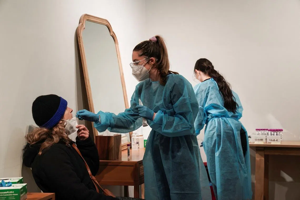 美国洛杉矶的一名医护人员正在为民众进行冠病检测。（路透社）