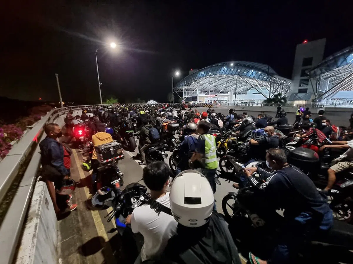 4月1日凌晨等着通关回马来西亚的骑士们。（联合早报）