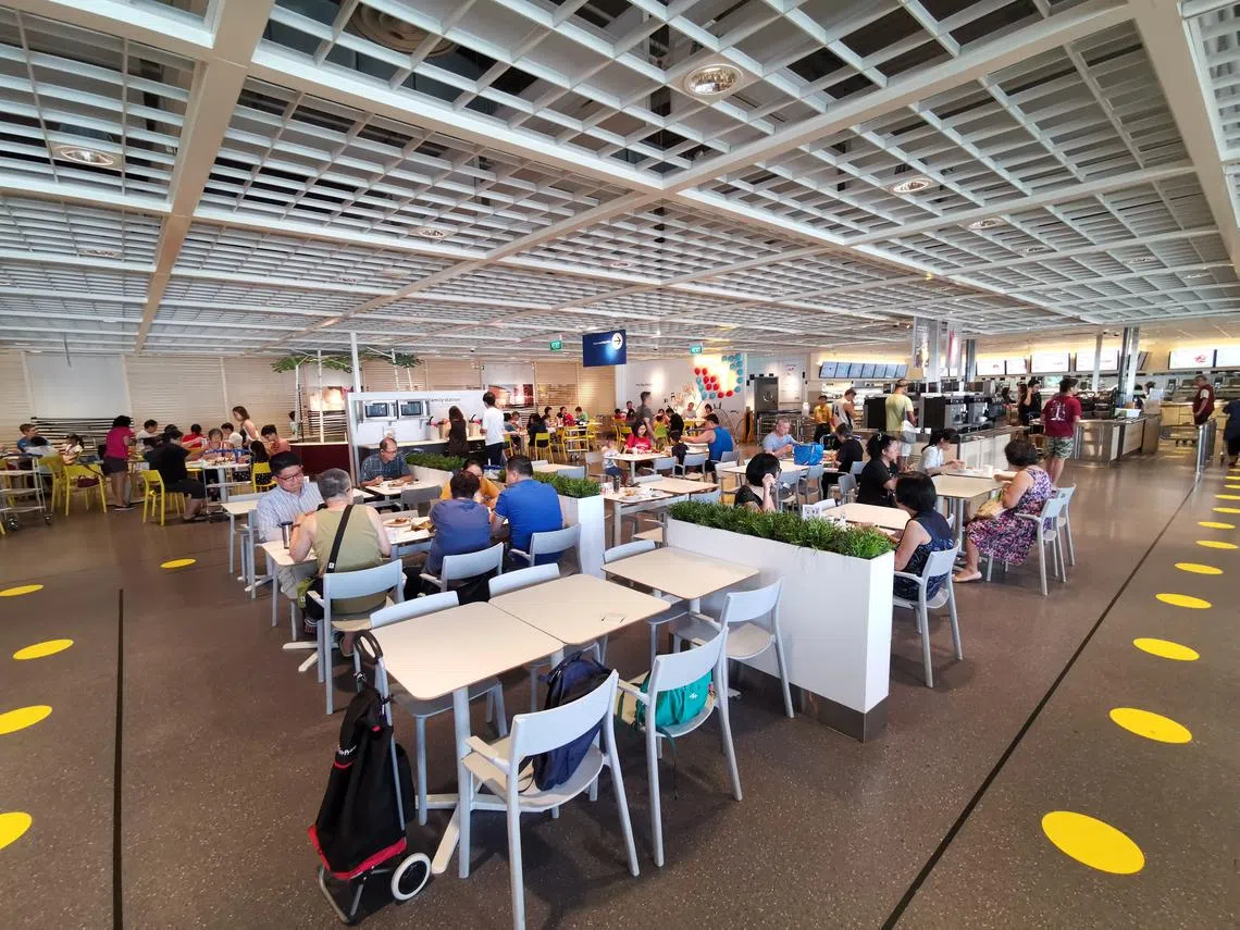 本地加强减少社交接触，增强社交距离。图中为家具店宜家落实的安全措施，其中包括减少摆放桌椅，以及在点餐区前贴上贴纸，提醒消费者保持社交距离等。（联合早报）