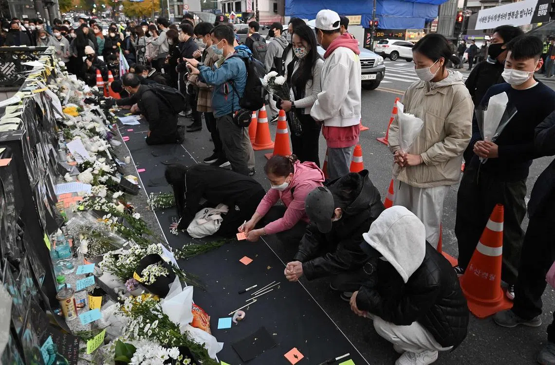 民众到梨泰院地铁站外哀悼踩踏事故的罹难者。（法新社）