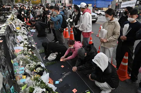 民众到梨泰院地铁站外哀悼踩踏事故的罹难者。（法新社）