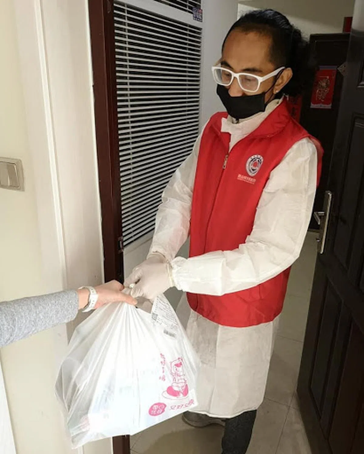  许春得协助居民将订购的食品从小区门外送到他们家门口。（许春得面簿） 