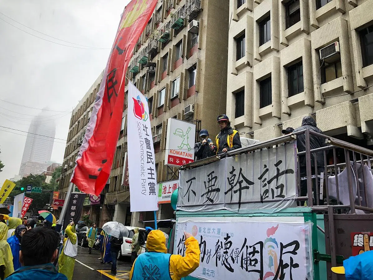  抗议者8日举着各种带谩骂字眼的标语。（联合早报） 