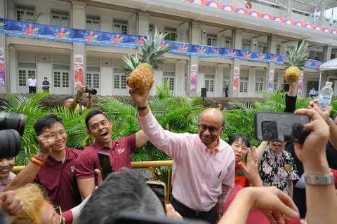 新加坡第九任总统尚达曼在提名日当天举起他的竞选标志：黄梨（Ong Lai，代表“旺来”的意思）。（海峡时报）