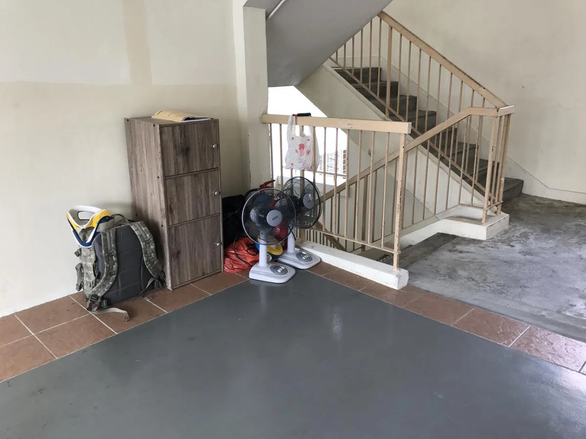  驻守在哈莉玛住家外的警卫，还有这些配备：延长插座、两把椅子、两部风扇，和几袋挂在电梯间水管上的咖啡。（卢凌之摄） 