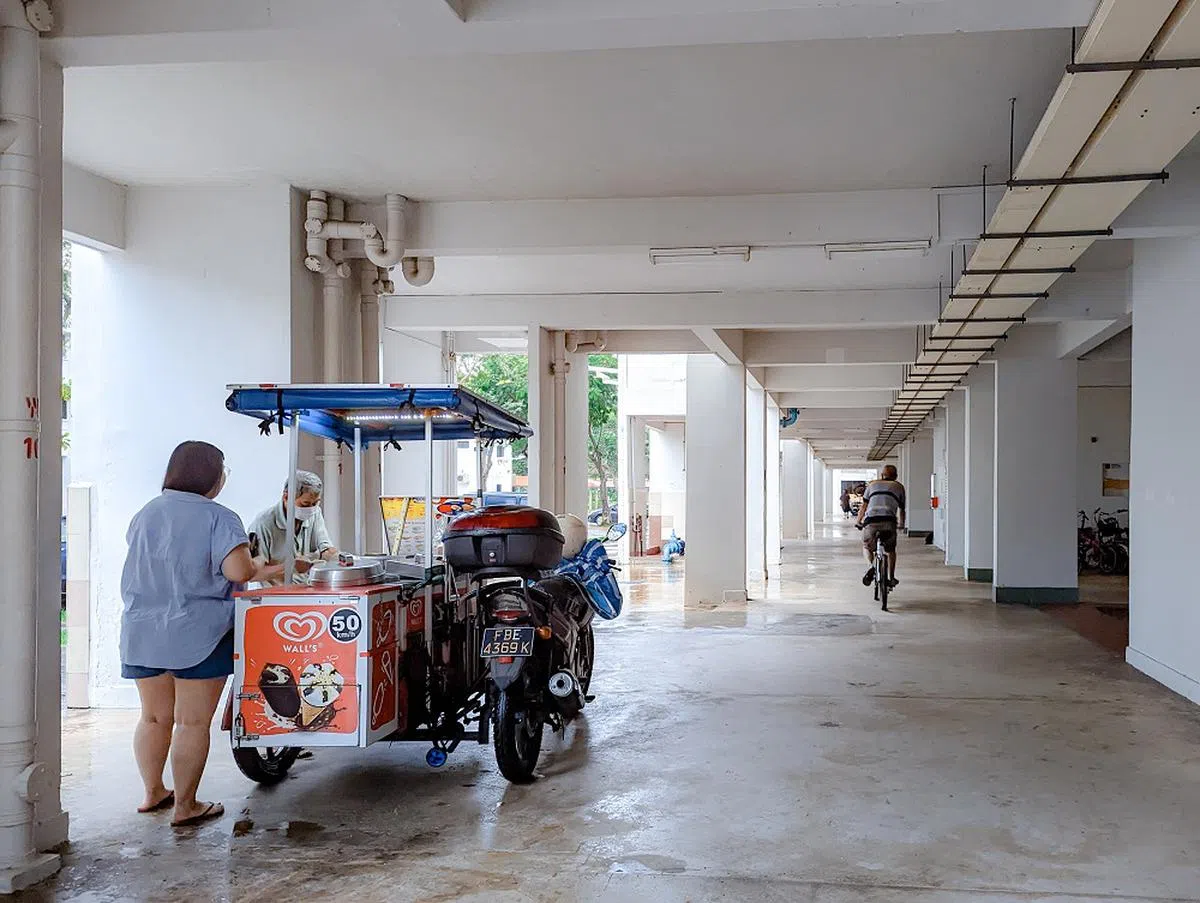 遇到下雨天，一些冰淇淋小贩会在组屋底层避雨。（联合早报）