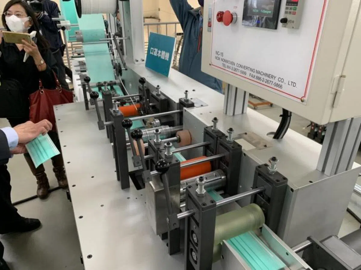  口罩的三层布料在这台机器上熔接成形，鼻梁的压条也在此处置入。（数位时代） 