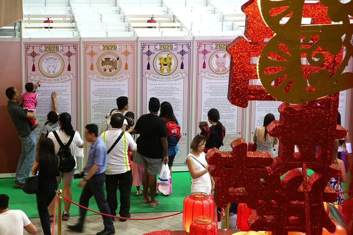 农历新年期间，以中英文注解的运程看板也吸引异族同胞驻足围观，充分展现新加坡独有的多元种族风貌。（联合早报）