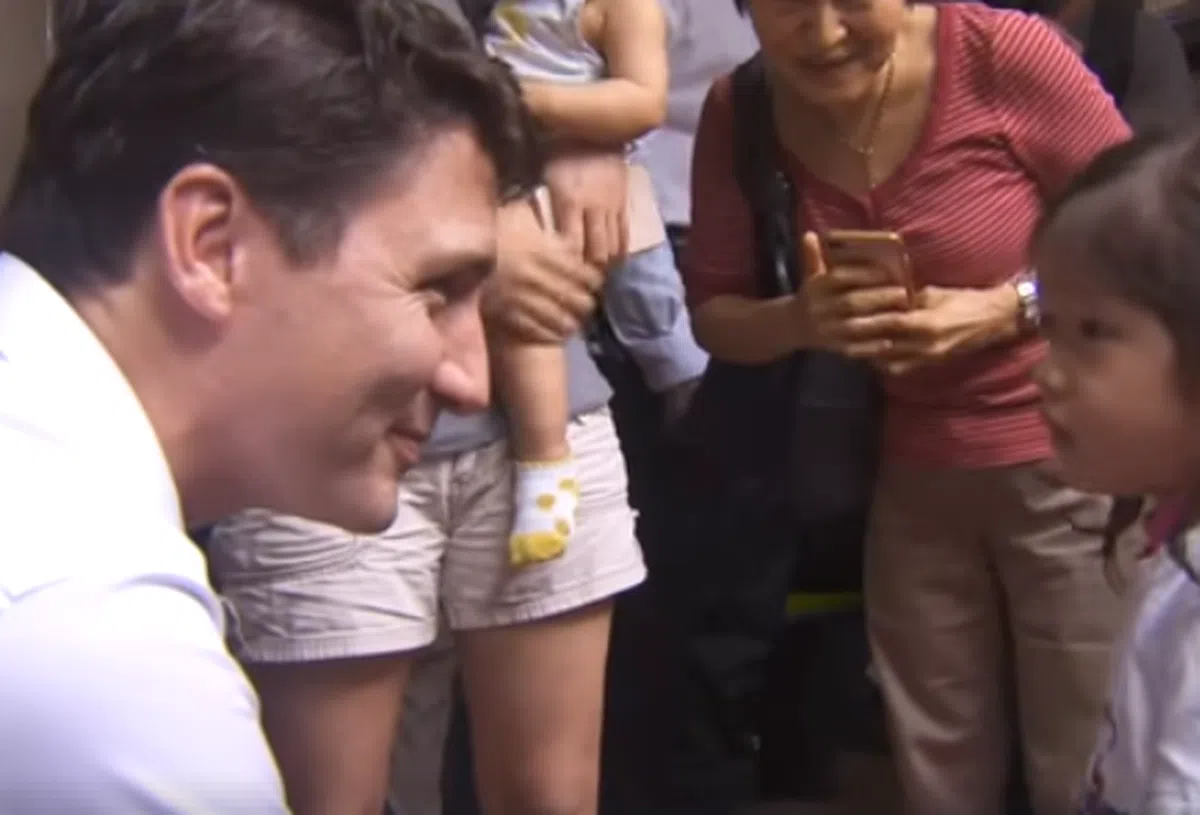  特鲁多蹲下来与新加坡的一名小妹妹亲切交谈。（视频截图） 