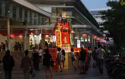 设在勿洛转换站小贩中心前面的财神爷塑像亮起灯来。（联合早报）