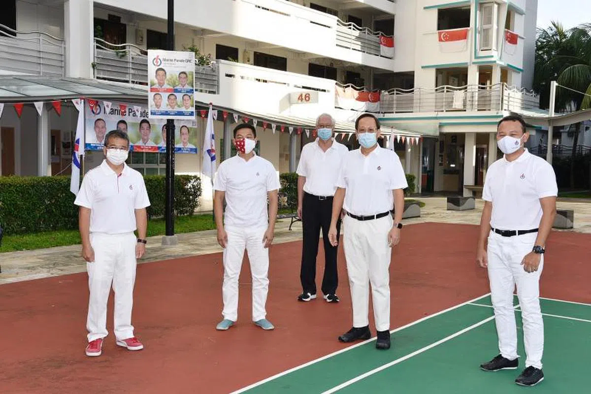  尽管已宣布引退，但吴作栋（中）仍在本届大选竞选期间陪同行动党候选人一同走访选民。（海峡时报） 