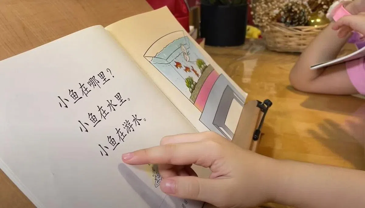曦恩为学生补课时会和他们一起朗读故事书。（海峡时报视频截图）