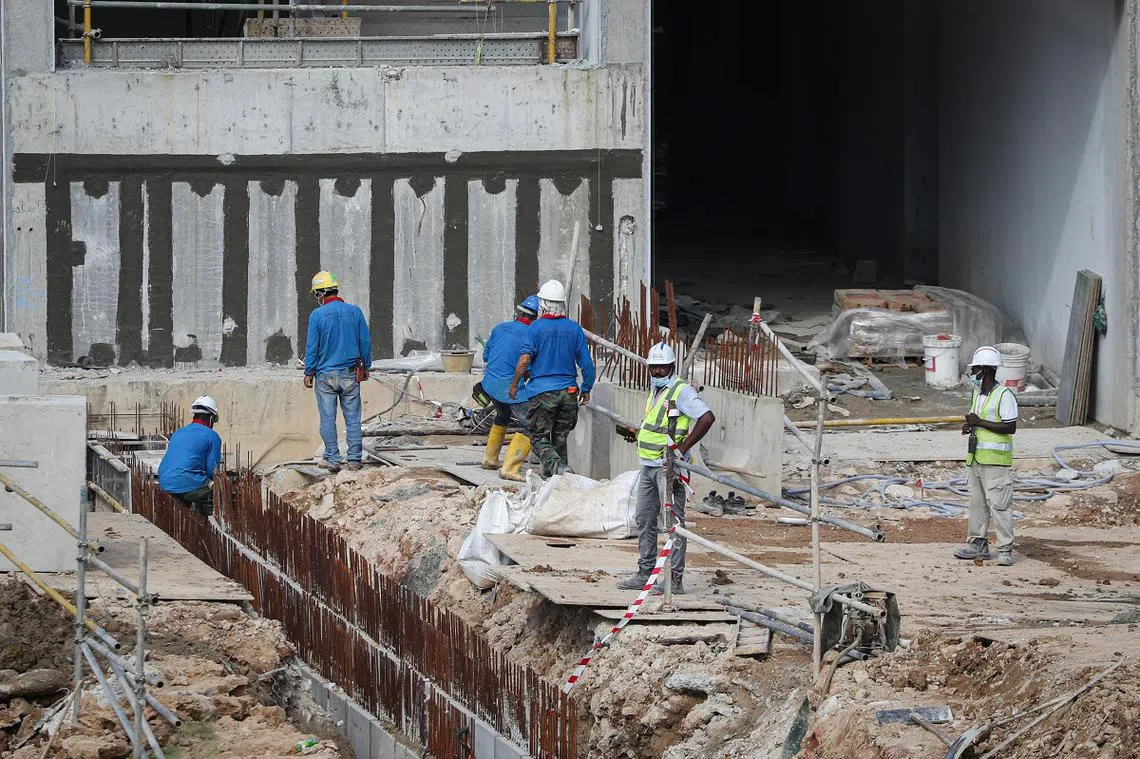位于淡滨尼北的一处工地，以及建筑工人。（联合早报）