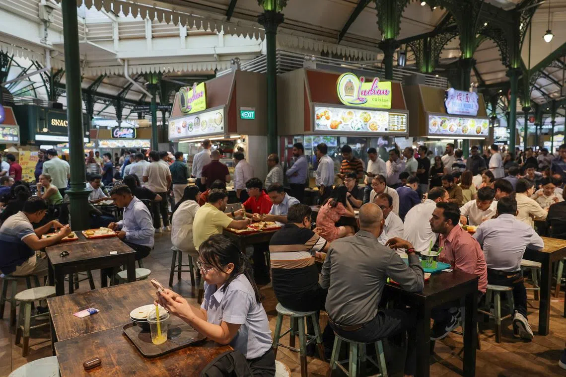 在老巴刹熟食中心内，经常可以看到不同种族的人一起用餐。（海峡时报）