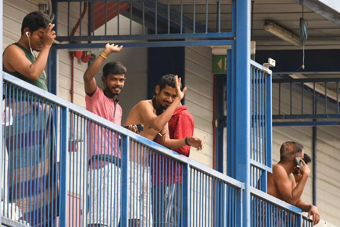 本地最大的客工感染群——榜鹅S11宿舍内的外籍客工发现记者在拍照，友善地挥手打招呼。（法新社）