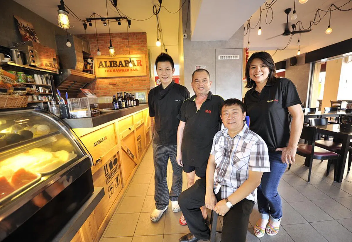  陈家全（坐在椅子上者）2014年接受《海峡时报》专访时与阿里巴巴一定好的其他摊主合影。（海峡时报） 