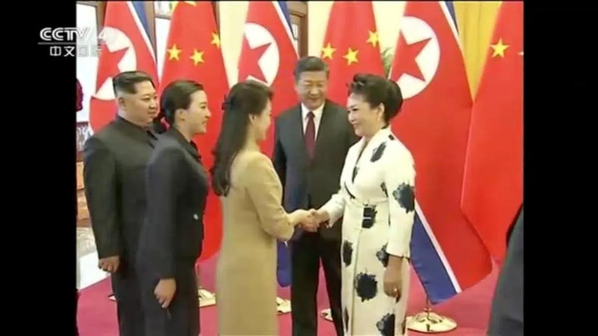  习近平夫人彭丽媛（右一）与金正恩夫人李雪主握手。（CCTV视频截图） 
