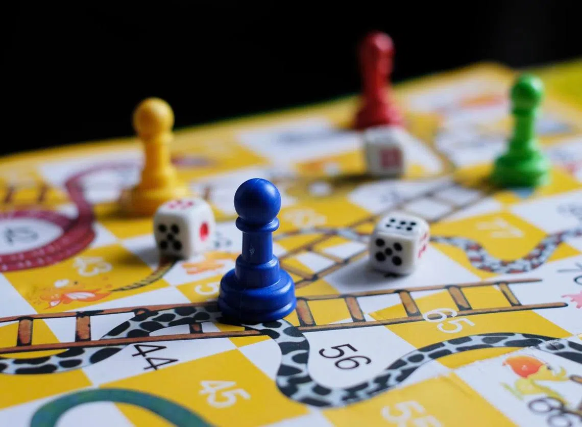 卫生部长王乙康将新加坡与未知的冠病变毒株“奥密克戎”（Omicron）的博弈过程，比喻为就像在下一盘“蛇梯棋”（Snakes and Ladders Game）。（王乙康面簿）