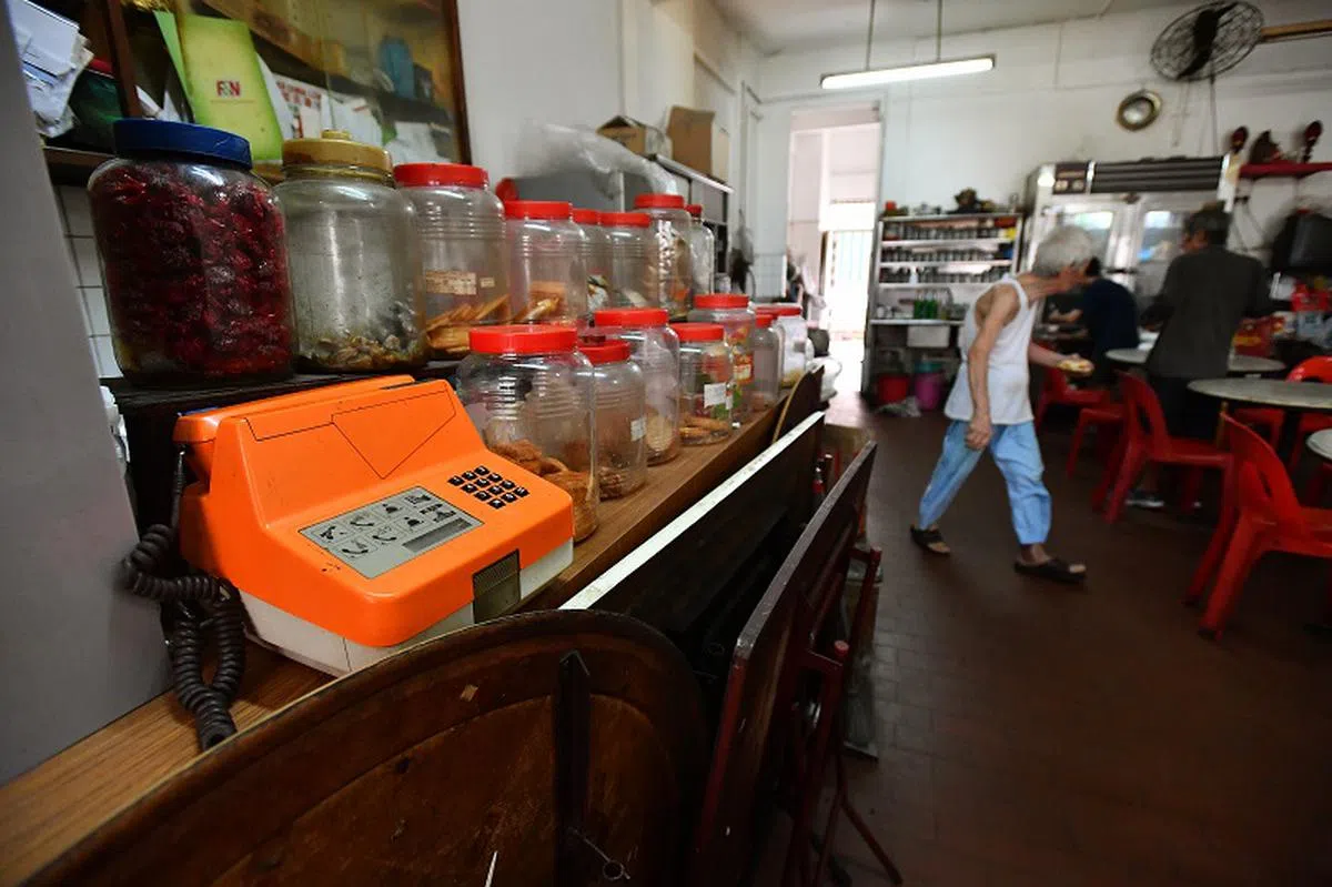 一些老字号的咖啡店，几年前还找得到橘色公共电话Coinafon。（海峡时报）