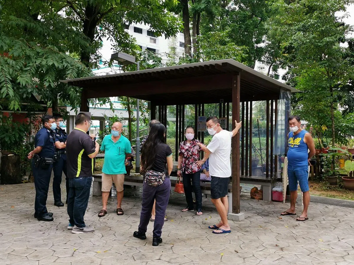  居民聚集在万国埔凉亭旁，阻拦当局人员拆除遮盖。市镇会也报了警。（新明日报） 