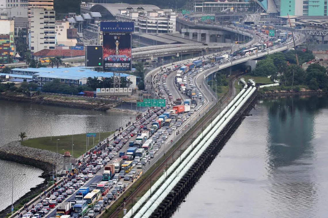 新马只是一带之隔，长长的车龙就是新柔长堤的标志。（联合晚报） 