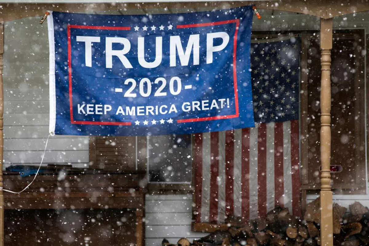 特朗普在密西根州的支持者在住家外悬挂支持特朗普连任的旗帜。（路透社） 