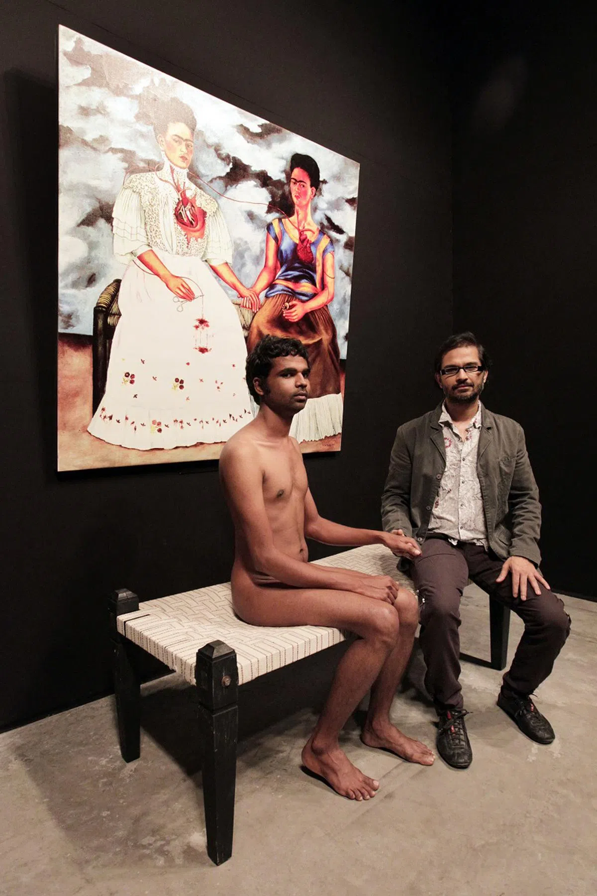  印度画家维坎纳在本地首届“艺术登陆新加坡”画展上，模拟1939年的一幅画作《两个弗里达》，全身裸露和参观者合照，当时一度引起争议。（新民日报） 