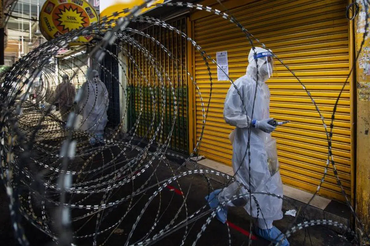  全副武装进入吉隆坡封锁区的马国前线医护人员。（路透社） 