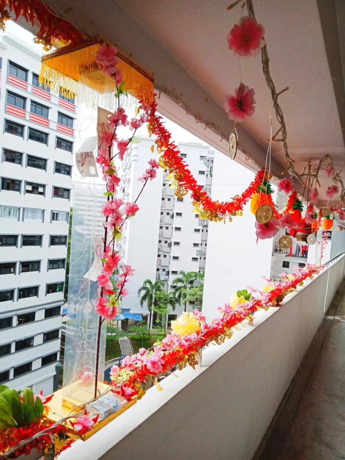  农历新年期间，居民在组屋区走廊自费布置。（新明日报） 