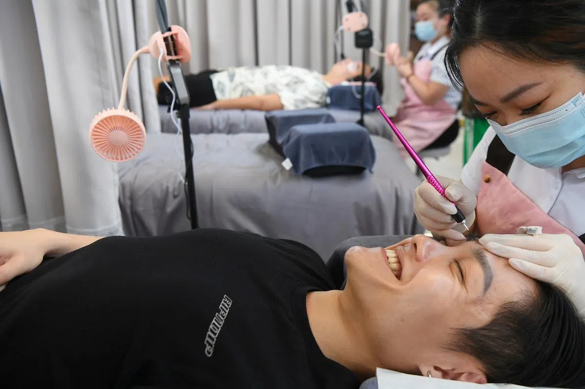 看这位仁兄还笑得出来，纹眉应该不痛吧？（海峡时报）