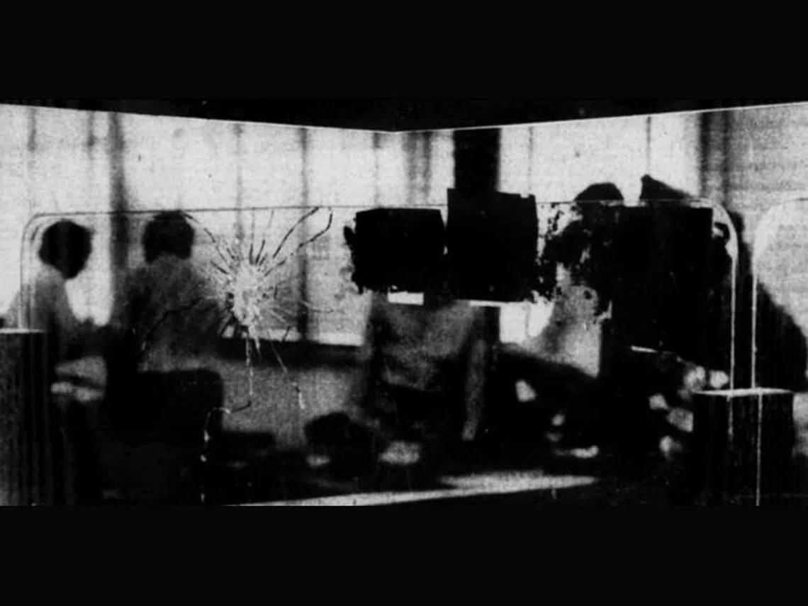 1980年3月19日，渣打银行又发生严重劫案。三匪头套女人尼龙丝袜，闯入武吉知马路上段13公里山景道渣打银行分行，连开三枪，射伤两名男出纳员，劫走5万余元。图为被子弹射穿的出纳台玻璃。（NewspaperSG截图）