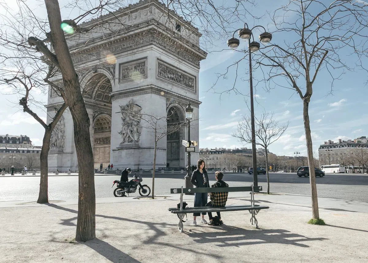  空旷的香榭丽舍大道，只有少数车辆和旅客在巴黎凯旋门附近经过与停留。（纽约时报） 