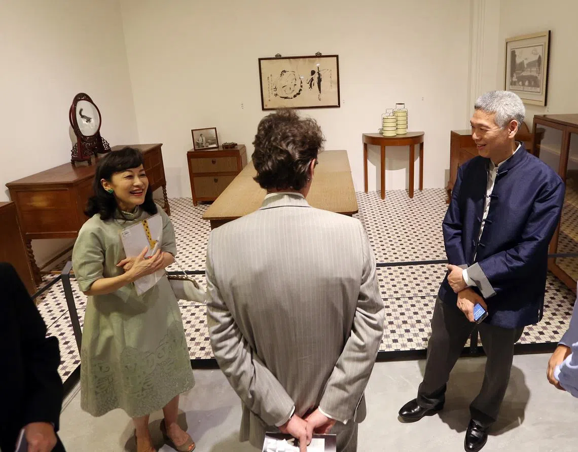 林学芬（左一）与丈夫李显扬（右一）2015年在国家博物院展出欧思礼路38号故居摆设的前一晚，向嘉宾讲解这些家具与展示品的用途。（海峡时报）