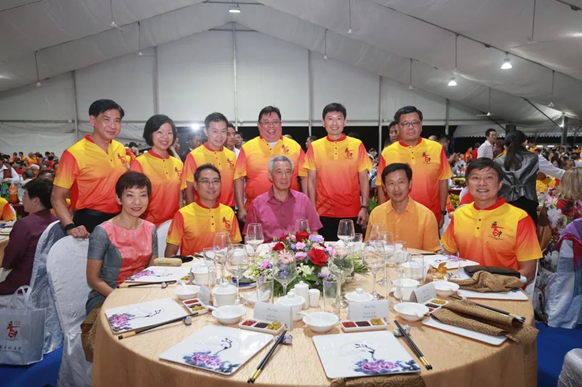  李显龙总理（前排左三）在万人宴上与华侨中学校长彭俊豪（前排左二）和多名第四代领导班子成员合照。（联合早报） 