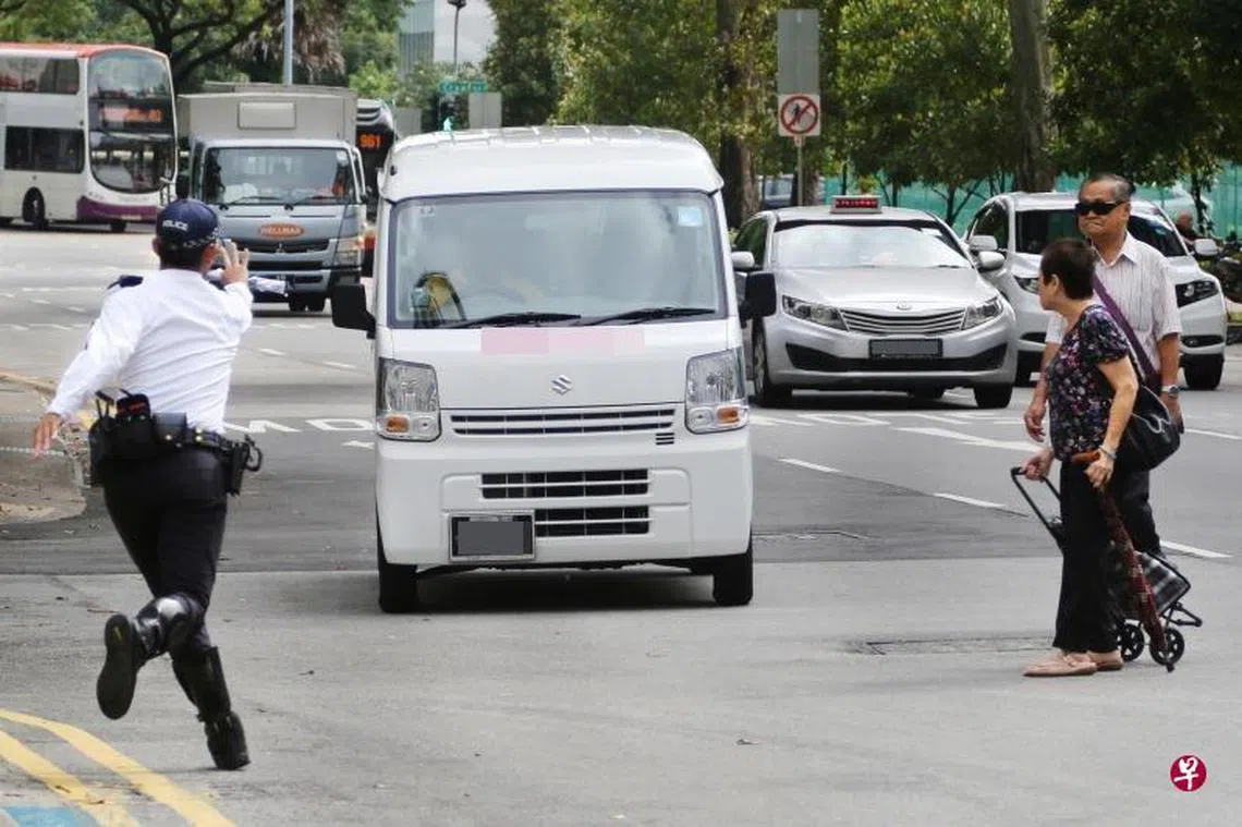 交警昨早在桥北路展开取缔行动，两名年长者违例过马路时，有辆货车突然转道，似乎要靠边停。交警见状，连忙上前制止，以免发生车祸。（联合早报）
