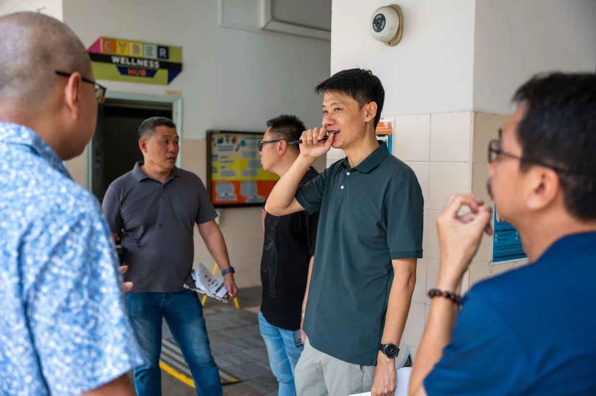 副警监David Ou 在指定为提名中心的学校，与同事和学校工作人员一起检查现场准备工作。（新加坡警察部队）