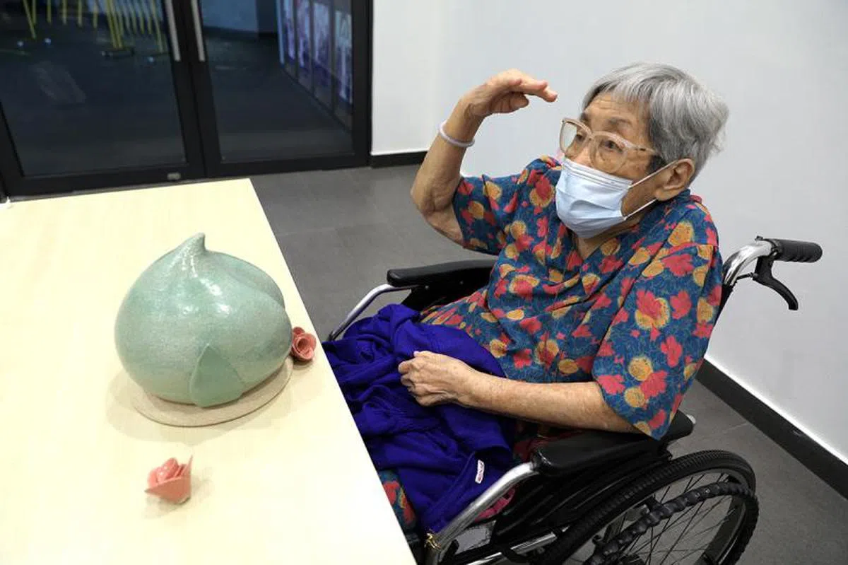 2020年10月23日，万女士看到她的骨灰瓮原型后，满意地向设计工程师Amanda Swee致敬。（海峡时报)