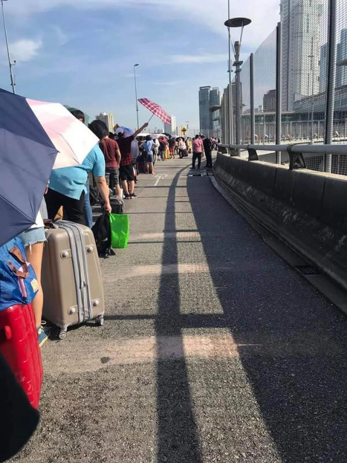  返马人士烈日当空下排队等待入境。（Malaysia-Singapore Border Crossings） 
