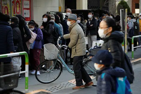 上个月28日，日本人带着口罩到药店排队买口罩。（路透社）