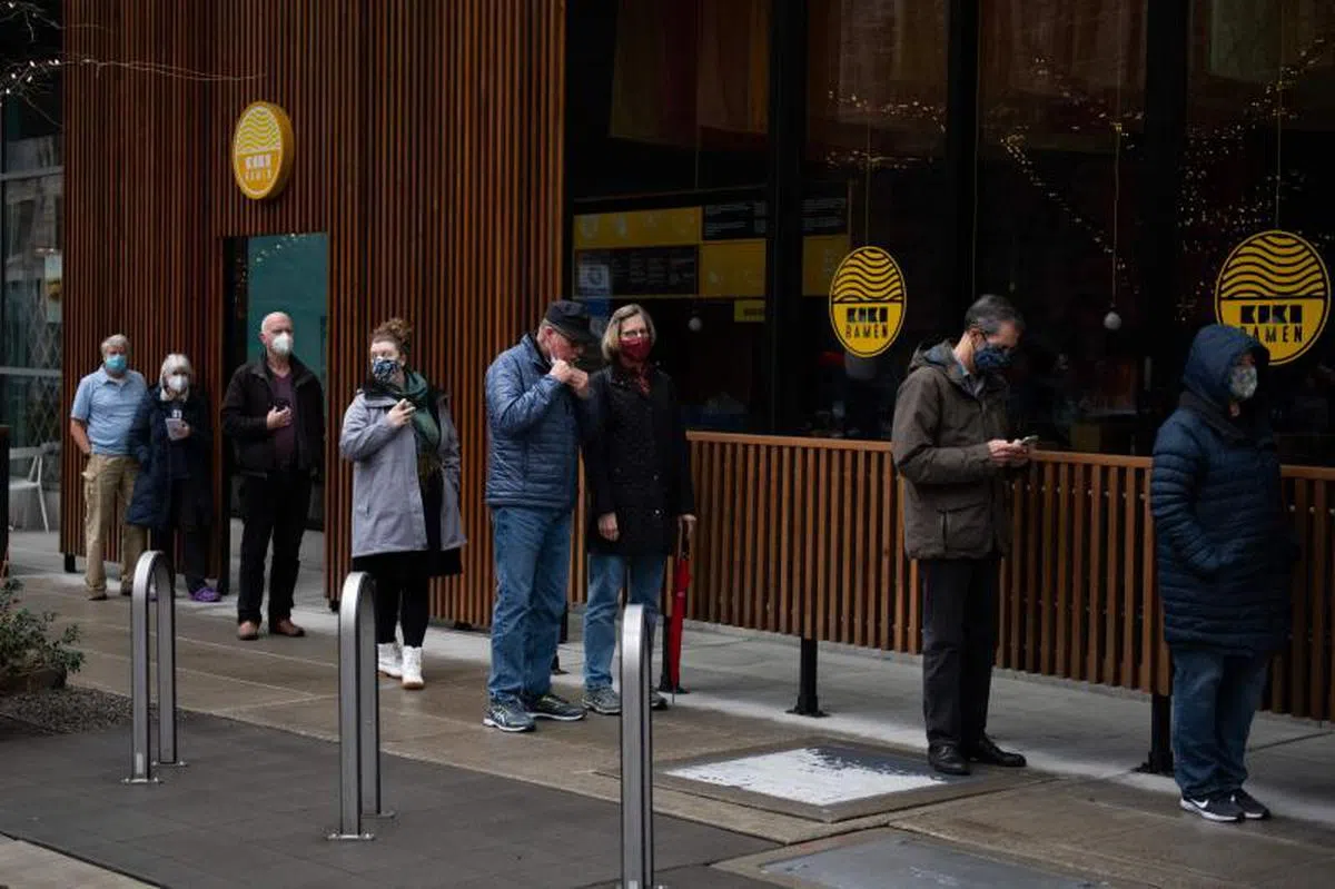  美国疫情几乎拖垮其经济。图为人们在西雅图准备接受疫苗注射。（法新社） 