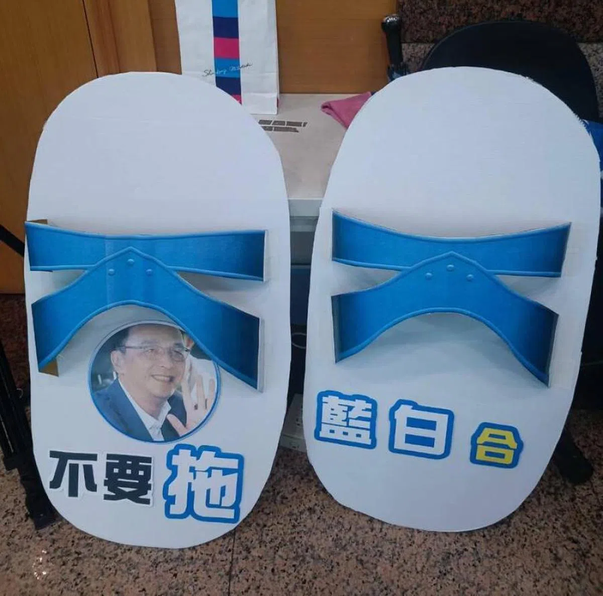 外界对蓝白合的前景不感乐观。图为示威群众到国民党总部送上大型蓝白拖，对蓝白合迟迟未成，变成“蓝白拖”表达不满。（自由时报）