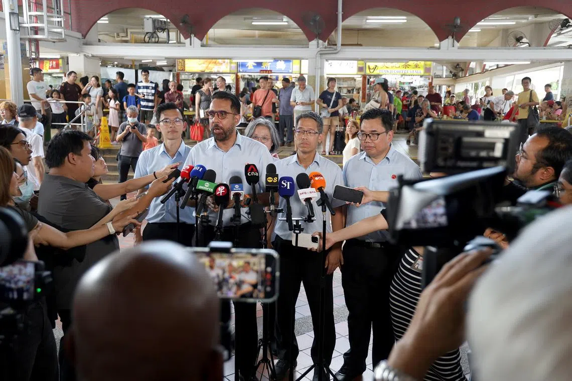 毕丹星（中）4月26日率领阿裕尼团队走访高文小贩中心，在媒体联访时交代了费沙与曾在本地担任回教宗教师、现居马来西亚的努尔德罗斯（Noor Deros）见面的来龙去脉。（海峡时报）