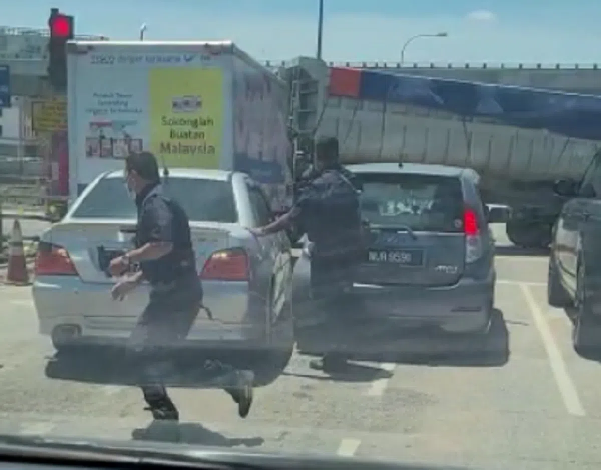  其中一名警察跑到逃逸的汽车另一侧。（视频截图） 