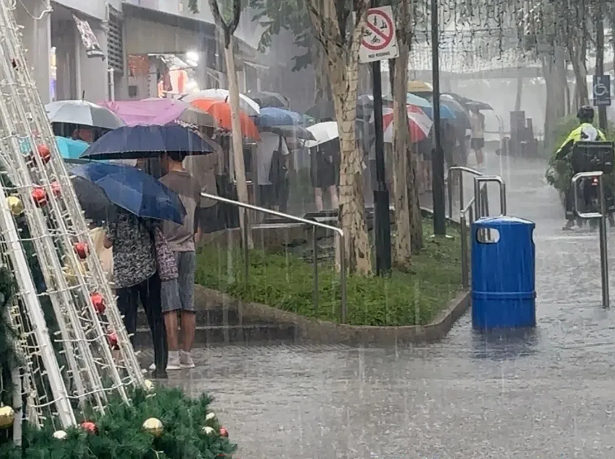 虽然最近全岛频频下雨，但仍无阻人们撑伞排队等着充值。
