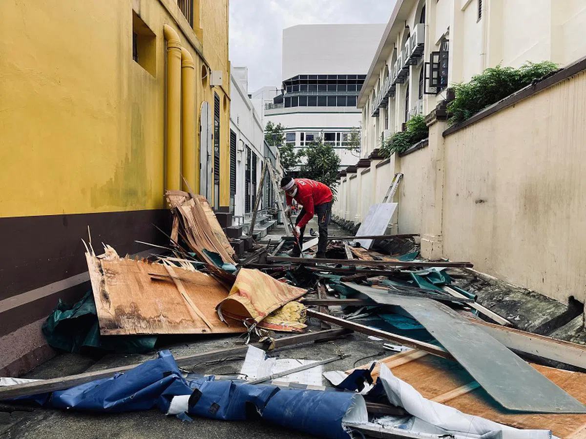 2月8日，几名工人将用来搭起这个后巷理发店面的遮篷、柱子、木板等一一拆除，准备用货车运走。（慈母舰）