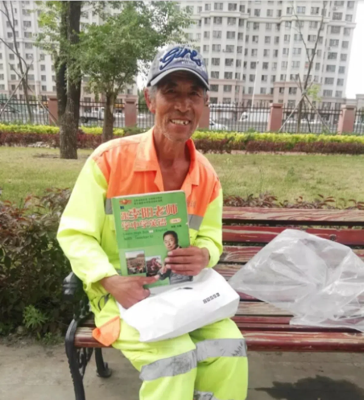  王寿山拿着李阳老师的书自学英语。（互联网） 